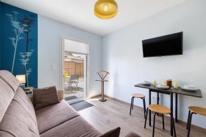 a living room with a couch and a table at Gite Logeraie in Le Boupère