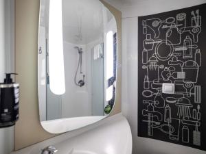 a bathroom with a mirror over a white sink at ibis London City - Shoreditch in London