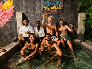 a group of people sitting in a pool drinking beer at Dreamy Hostel Arugambay in Arugam Bay