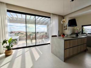 a kitchen with a view of a patio with a table at Sunset Horizon Lagonisi in Kalívia Thorikoú