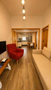 a living room with a couch and a red chair at Primero el Wiro in Puerto