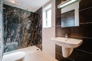 a bathroom with a sink and a shower and a toilet at The Penthouse @ Carus Green in Kendal +26 photos