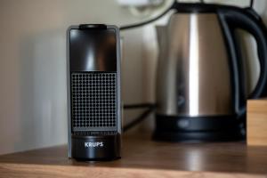 a cell phone sitting on a table next to a kettle at Fourka Garden Villas in Fourka