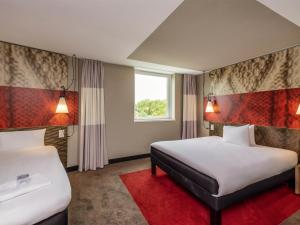 a hotel room with two beds and a window at ibis Bern Expo in Bern +72 photos