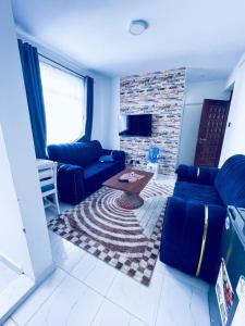 a living room with a blue couch and a fireplace at one bedroom airbnb with swimmingpool, kiambu road in Kiambu