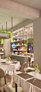 a dining room with white tables and chairs and a restaurant at Shelton's Rezidor Peshawar in Peshawar