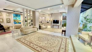 a living room with couches chairs and a television at Shelton's Rezidor Peshawar in Peshawar