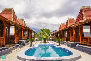 a resort with a swimming pool in front of a building at Instay Villa Dieng Kademangan in Wonosobo