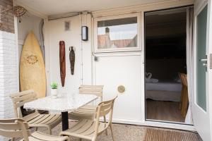 a patio with a table and chairs and a door with a surfboard at Hotel Nine in Zandvoort