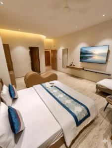 a hotel room with a large bed and a flat screen tv at Hotel VD Rooms Althan in Surat +22 photos