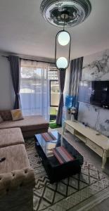 a living room with a couch and a tv at Dolphin Homestays in Nairobi