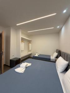 a room with two beds and two towels at Aura Rooms in Delvinë