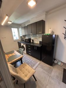 a kitchen with a black refrigerator and a table and chairs at Ralfi in Alba Iulia +11 photos