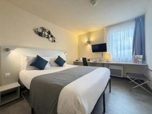a hotel room with a large bed and a desk at The Originals City, Hôtel Le Forum, Strasbourg Nord in Schiltigheim +28 photos