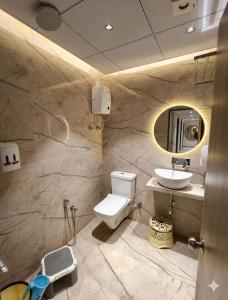 a bathroom with a toilet and a sink at Hotel VD Rooms Althan in Surat