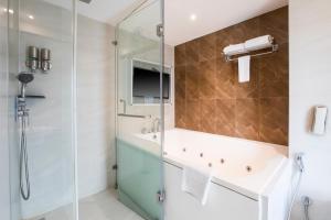 a bathroom with a glass shower and a sink at Ramee Techome in Mumbai +62 photos