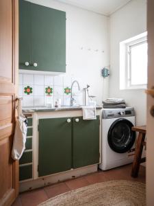a kitchen with green cabinets and a washing machine at Spacious Villa near Gothenburg in Alingsås