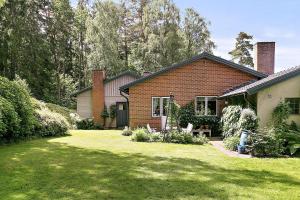 a brick house with a lawn in front of it at Spacious Villa near Gothenburg in Alingsås