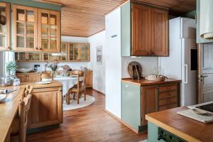 a kitchen with wooden cabinets and a dining room at Spacious Villa near Gothenburg in Alingsås