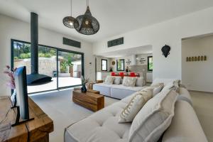 a living room with a white couch and a tv at Caray - Managed by Almarina Villas in Benissa