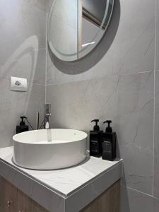 a bathroom with a white sink and a mirror at Aura Rooms in Delvinë