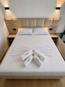 a bed with two towels on top of it at ALZETA Aparthotel in Durrës