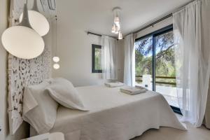 a white bedroom with a bed and a large window at Caray - Managed by Almarina Villas in Benissa +99 photos