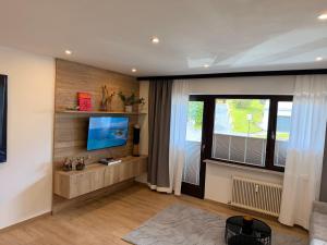 a living room with a television and a window at Excelsior Top 17 Alpenherz in Seefeld in Tirol