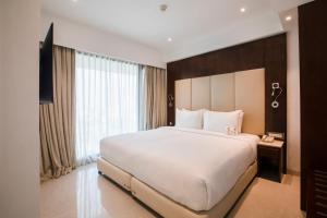 a bedroom with a large bed and a large window at Ramee Techome in Mumbai