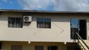 un perro asomando la cabeza por la ventana de una casa en Apto 103 Maria Helena, en Torres 1 foto más