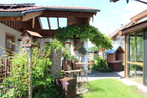 a garden with a house with a pergola at Fewo Obermoos in Teisendorf