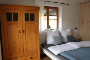 a bedroom with two beds and a wooden cabinet at Fewo Obermoos in Teisendorf