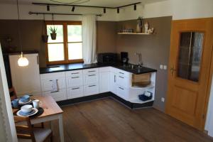 a kitchen with white cabinets and a table and a window at Fewo Obermoos in Teisendorf
