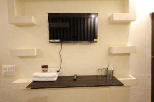 a bathroom with a towel and a tv on a wall at Hotel Marina in Meerut