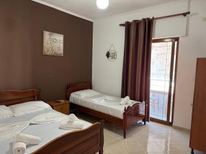 a bedroom with two beds and a window with a view at Villa Mare Blue in Ksamil