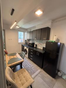 a kitchen with a black refrigerator and a table at Ralfi in Alba Iulia