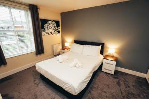 a bedroom with a bed with white sheets and a window at Dalby House in Derby