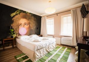 a bedroom with a painting of a woman with a pink balloon at Hotel Nine in Zandvoort