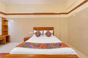 a bedroom with a large bed with two pillows at FabHotel Sca - Gandhipuram in Coimbatore +26 photos