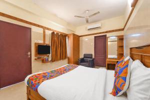 a hotel room with a bed and a television at FabHotel Sca - Gandhipuram in Coimbatore