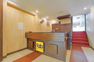a lobby with a reception counter and a staircase at FabHotel Sca - Gandhipuram in Coimbatore