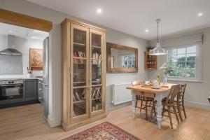 a kitchen with a wooden table and a dining room at Claytons Hideaway in Adlestrop