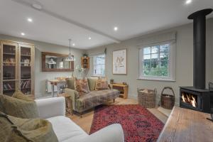 a living room with a couch and a fireplace at Claytons Hideaway in Adlestrop