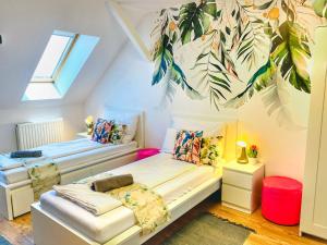 a attic room with two beds and a window at Magenta Apartman in Mórahalom