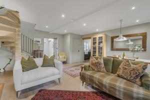 a living room with two couches and a kitchen at Claytons Hideaway in Adlestrop +17 photos