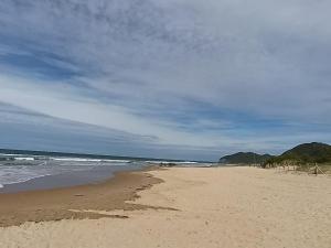a sandy beach with the ocean on a cloudy day at piso en la playa in Noja