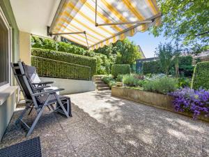 a patio with a chair under a pergola at Ferienwohnung am Bächler in Hagnau
