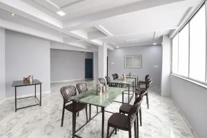a meeting room with tables and chairs and a projection screen at FabHotel Ojas Inn in Pune