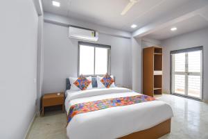 a bedroom with a large bed and a window at FabHotel Ojas Inn in Pune +21 photos