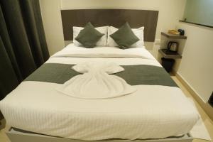 a white dress on a bed in a room at Aurelia INN - JP Nagar in Bangalore +35 photos
